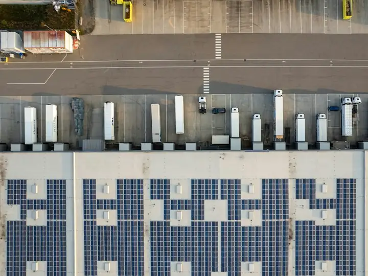 Vista aérea de galpão logístico com telhado coberto de módulos solares