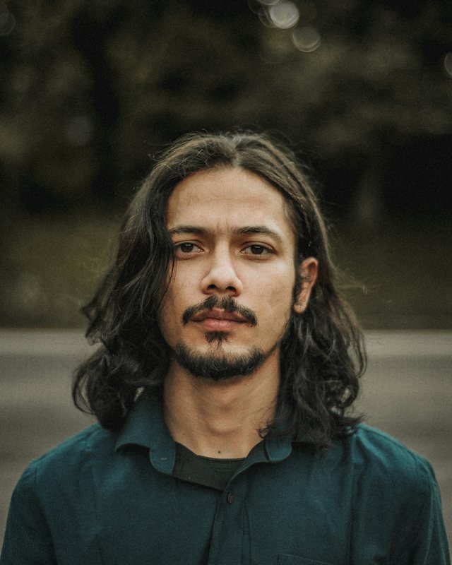 Homem de cabelo comprido e barba por fazer