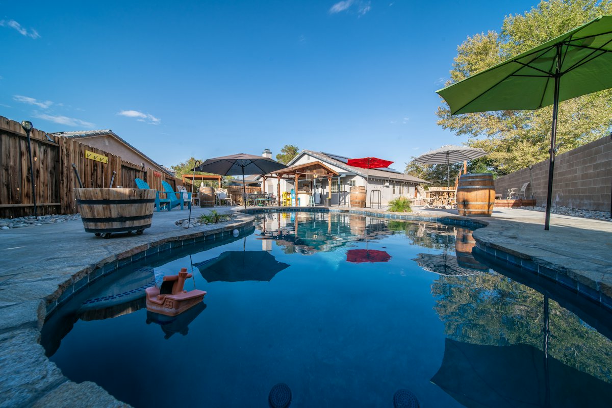 Piscina com guarda-sol e área de lazer coberta